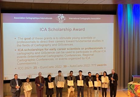 Winners of the ICA Scholarship Award stand in front of a stage to be honored for the achievement