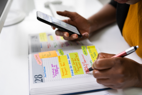 A student making notes in a paper and virtual calendar