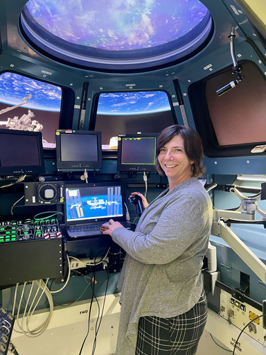 Portrait of Amanda Acevedo standing in an ISS CUpola Training Simulator