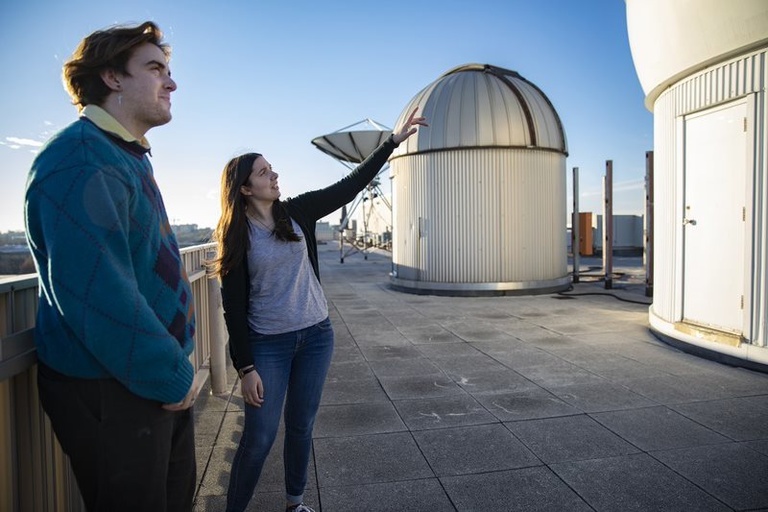 Two students looking upwards at the Van Allen Observatory