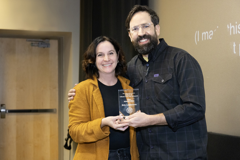 Dean Sara Sanders (left)  presents the CLAS Alumni Fellow award to Eric Leiderman (right)