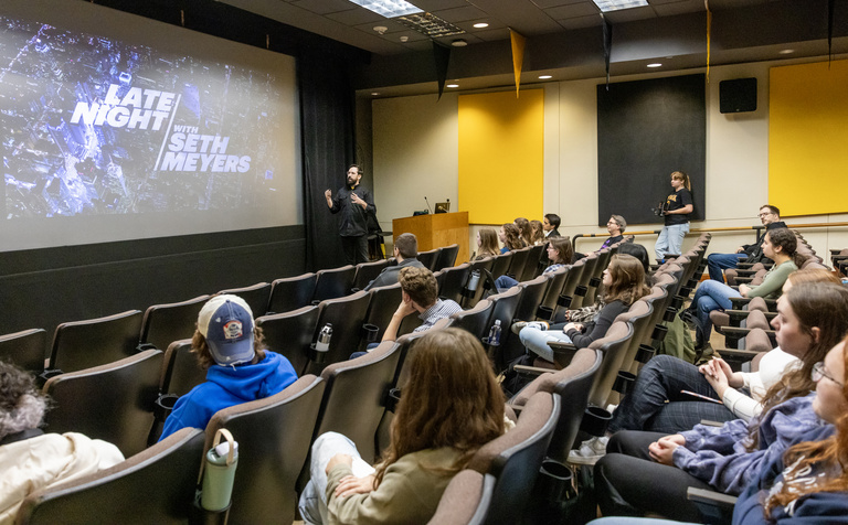 CLAS Alumni Fellow Eric Leiderman speaks to a crowd in the Iowa Theater at the IMU