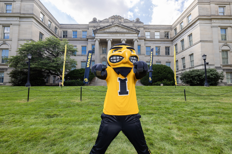 Herky stands in front of Schaeffer Hall and points at camera.