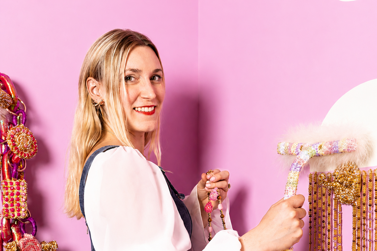Ali Hval holds rhinestone-covered paint-roller in a pink, bedazzled room