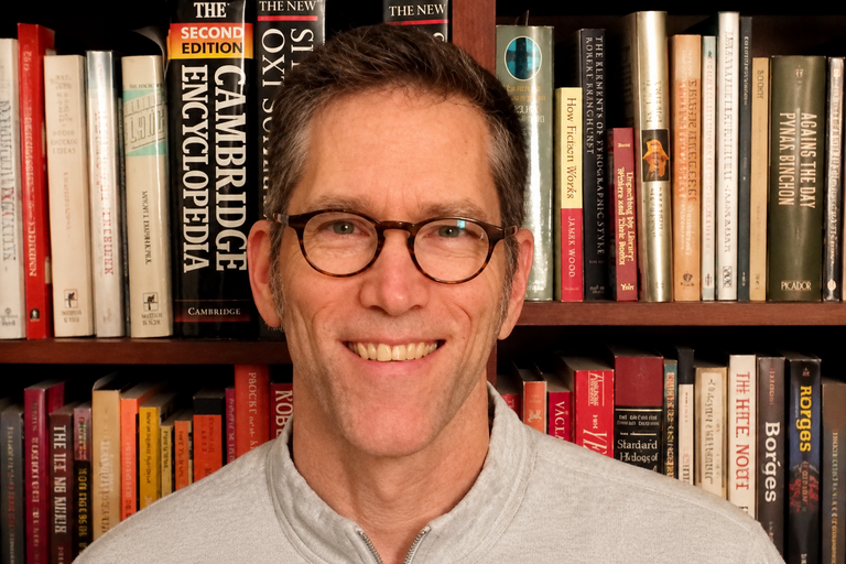 Image: Matthew Brown standing in front of bookcase 