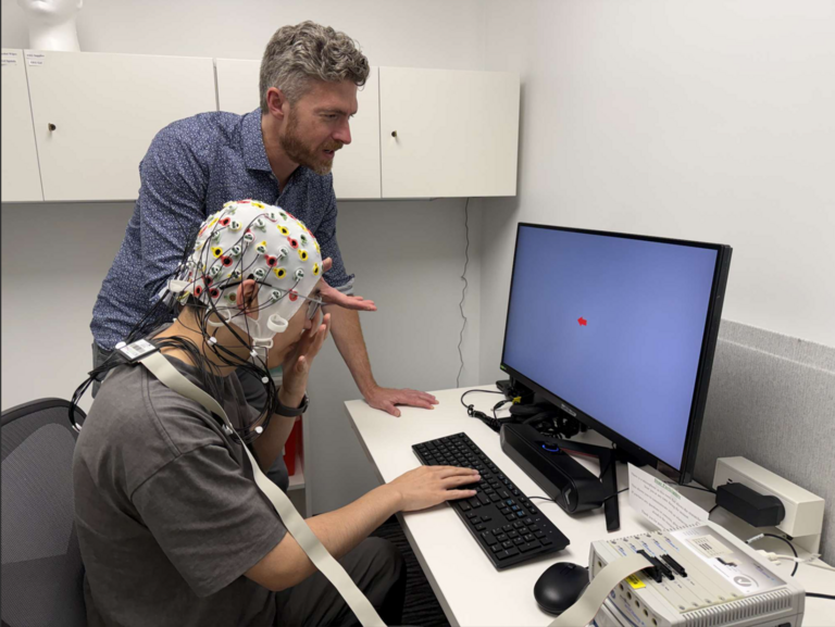 Jeffrey Cockburn guides a research participant at a computer