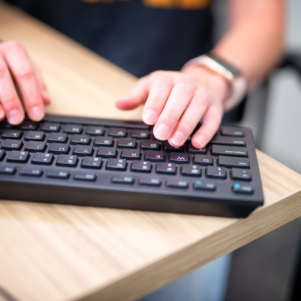 A staff person typing on a computer