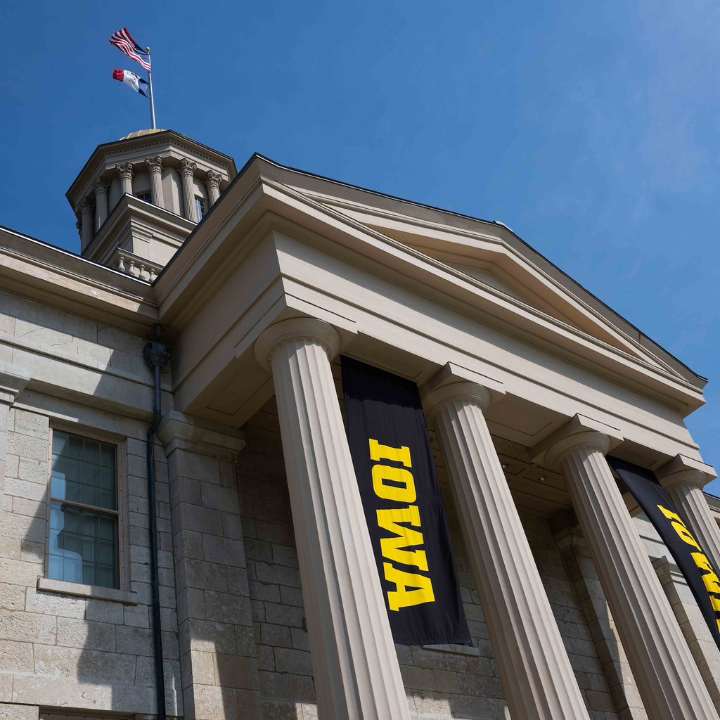 Block Iowa flags hanging from Old Capitol