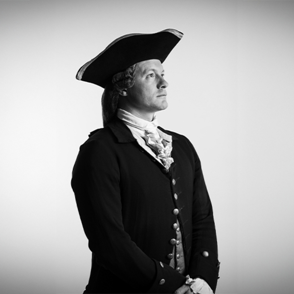 A black and white photograph of UI alumn, Kurt Smith, standing in costume as Thomas Jefferson