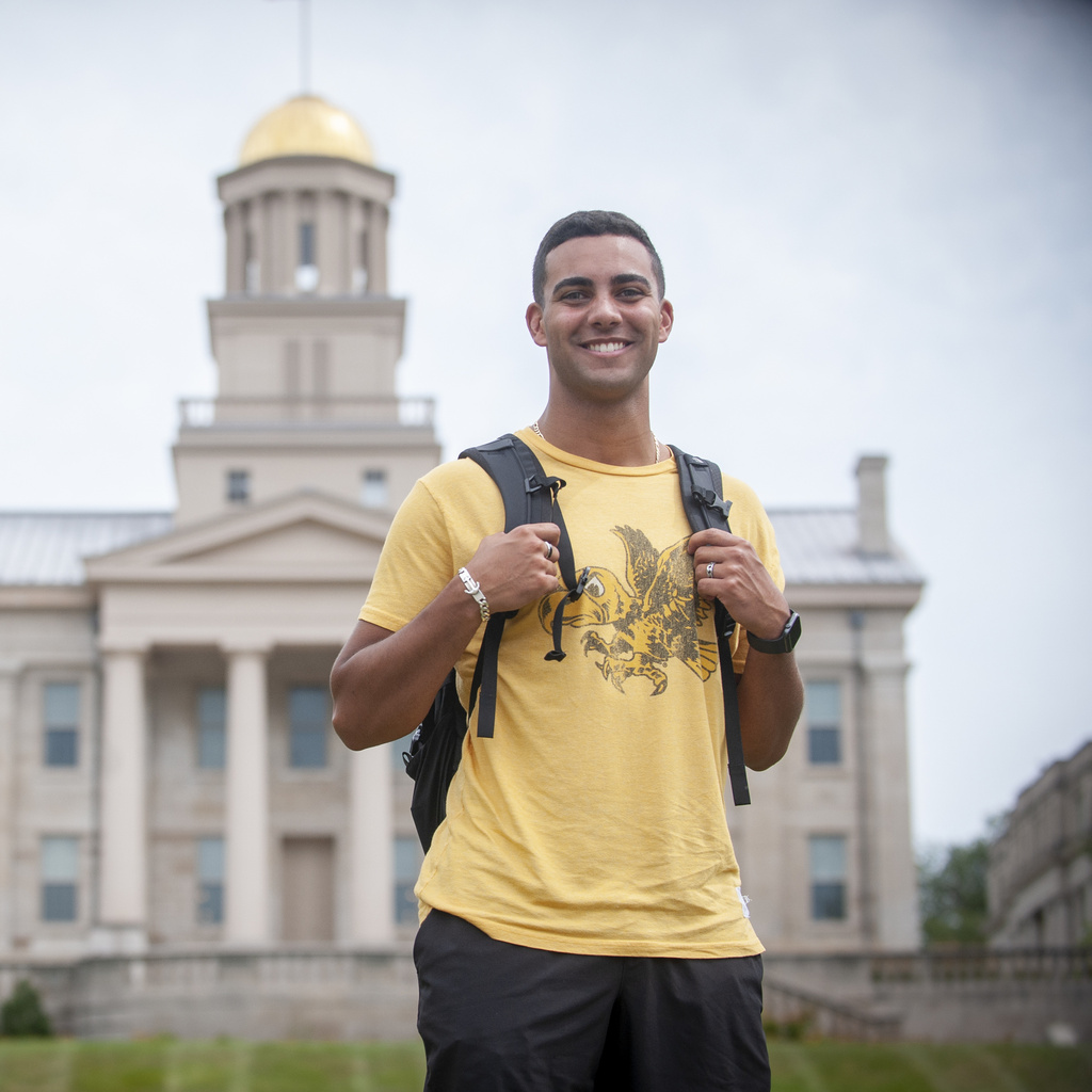 Student smiling for the camera with the Old Capitol building in the background