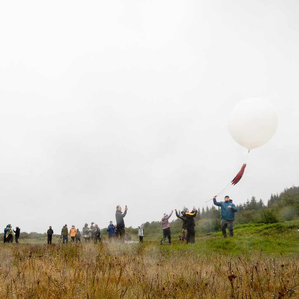 Members of the University of Iowa team watch a weather balloon ascend during their July expedition in Iceland.