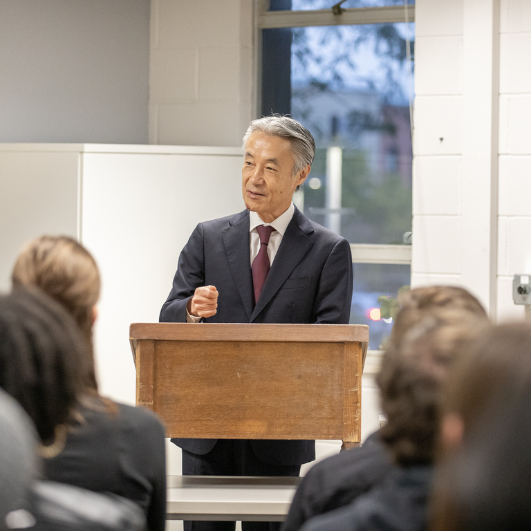 The Japanese Ambassador speaking at a podium in front of students