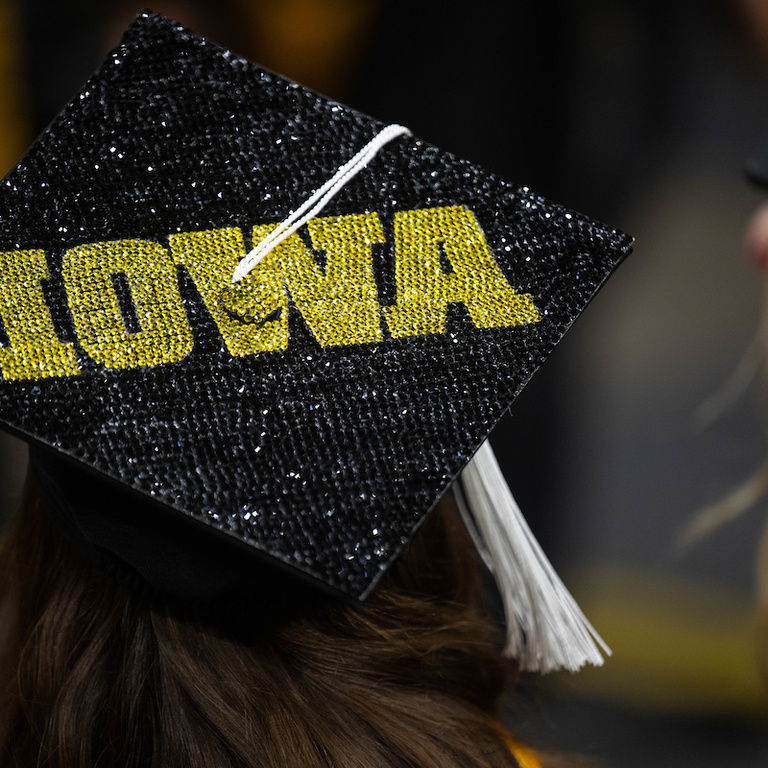 A decorated graduation cap that says IOWA in rhinestones