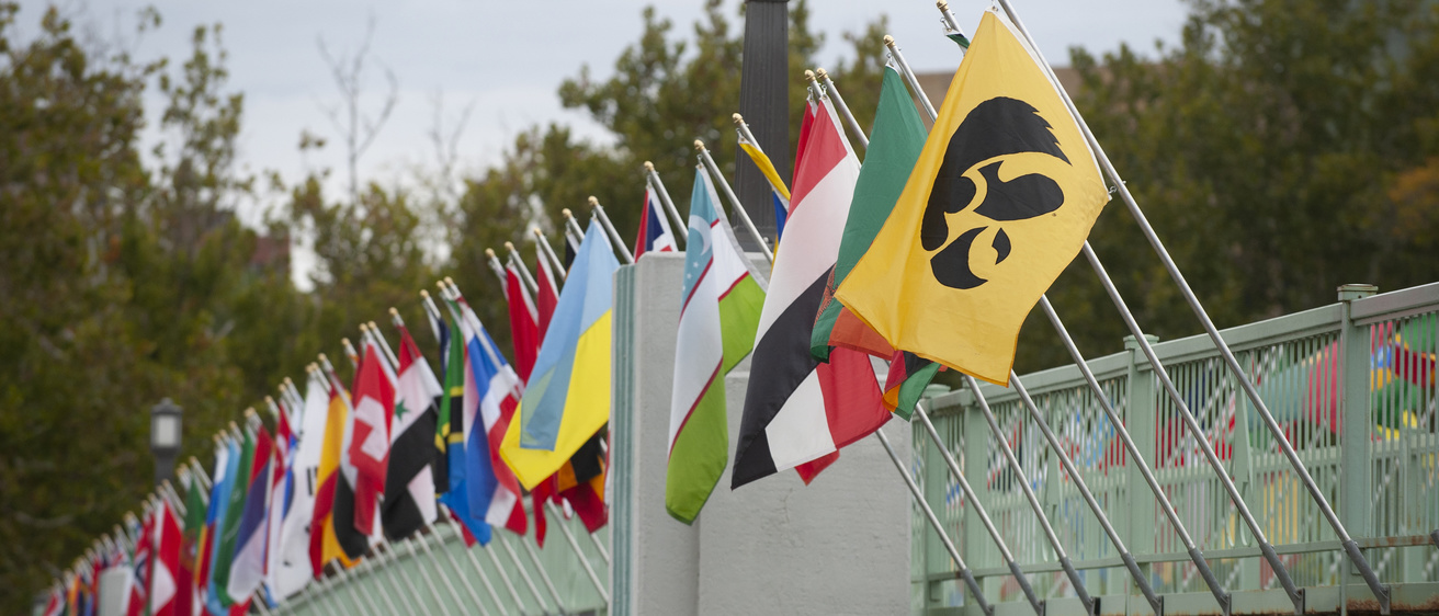 International flags hanging off a bridge on the University of Iowa campus