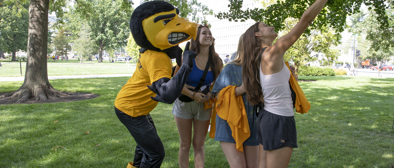 students taking a selfie on the Pentacrest with Herky