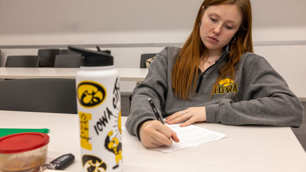 A student in hawkeye gear working hard at studying