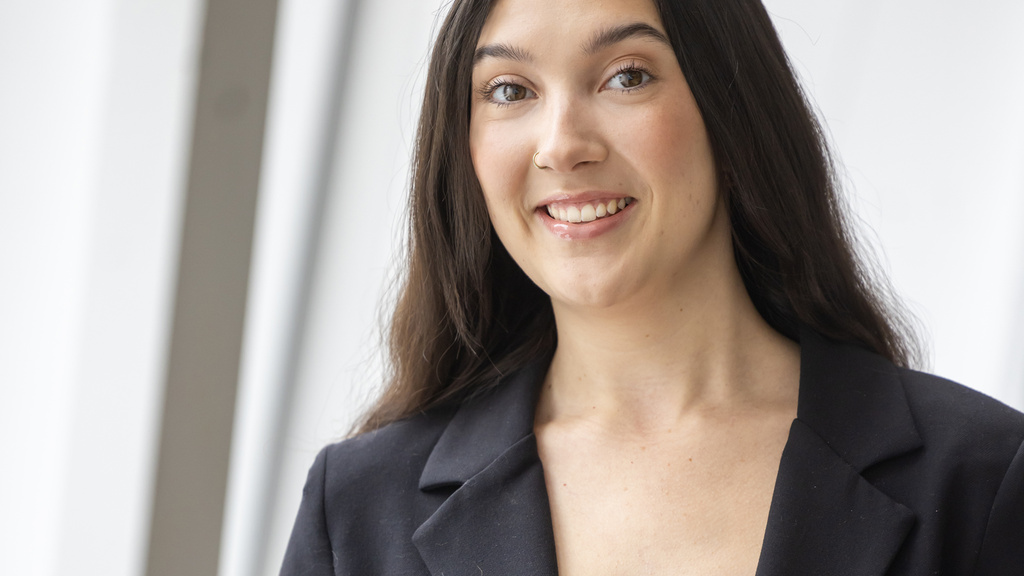 Commencement singer Sage Johnson stands next to a window in the UI Voxman Music Building
