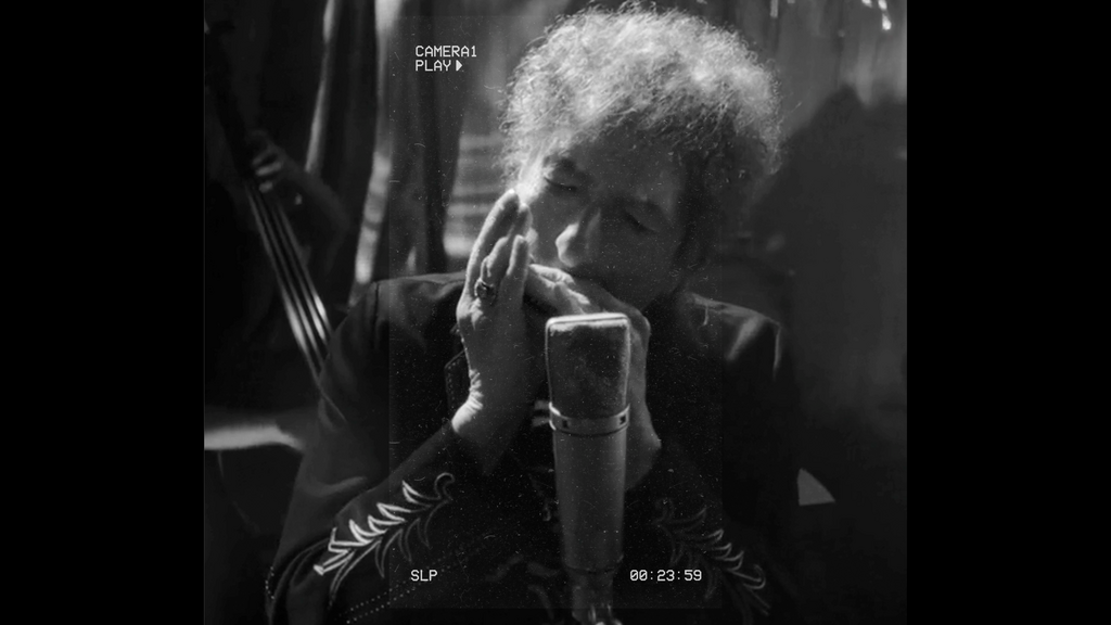 Bob Dylan playing harmonica, black and white photograph 