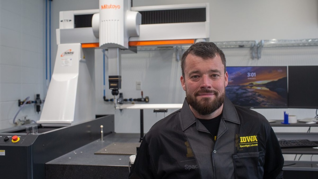 Richard Dvorsky, the Aerospace Principal Engineer, poses for a portrait in front of the coordinate measuring machine in the space lab in Van Allen Hall, Iowa City, Iowa, on Monday, April 13, 2026. 
