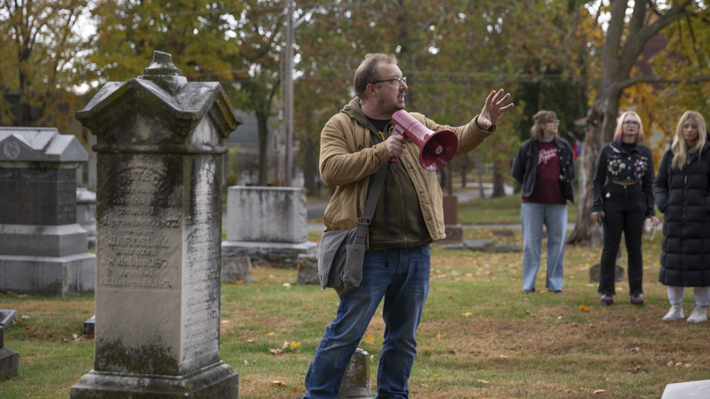 students on a cemetary walk with a religious studies professor