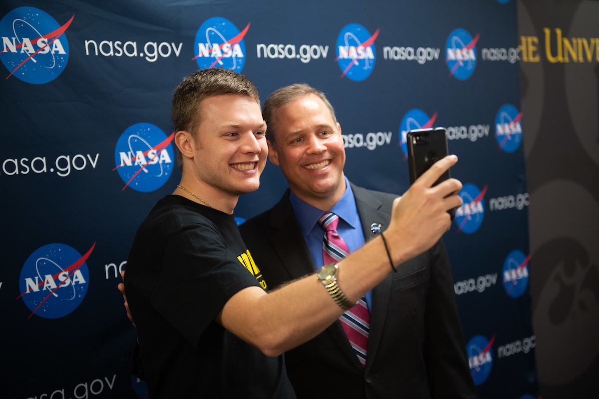 The administrator of NASA poses for a photo with a University of Iowa student