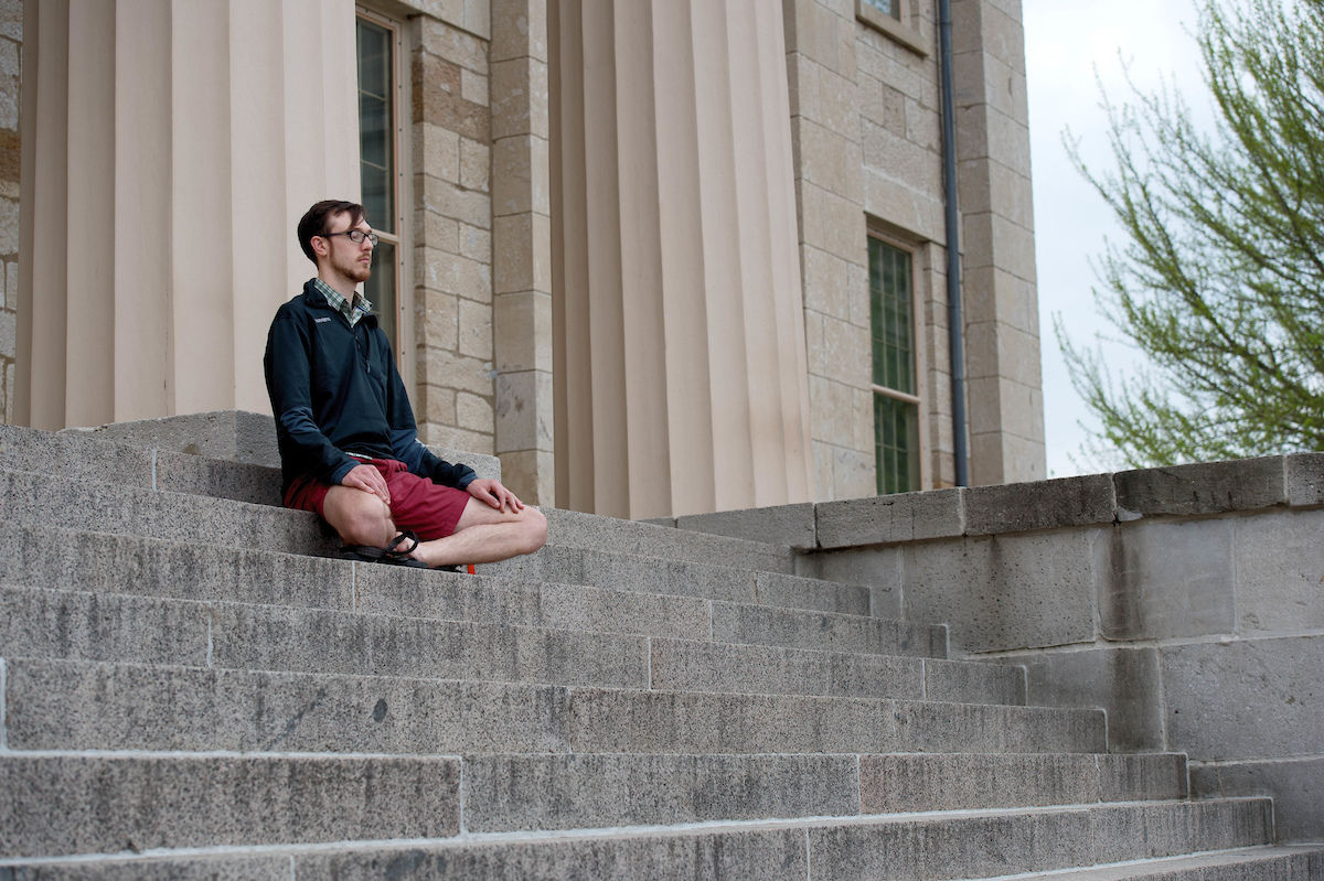 A man meditating on the steps of Old Capitol